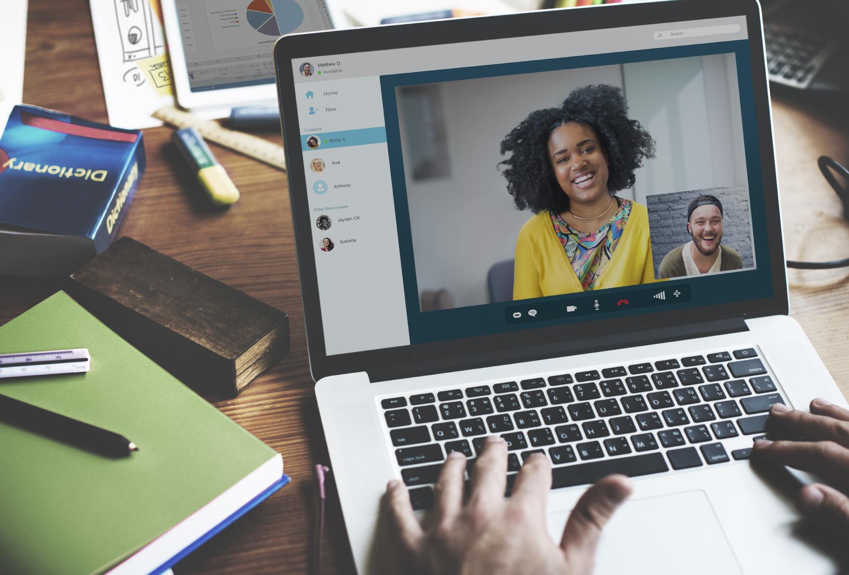 virtual meeting video call and hands typing on a laptop keyboard