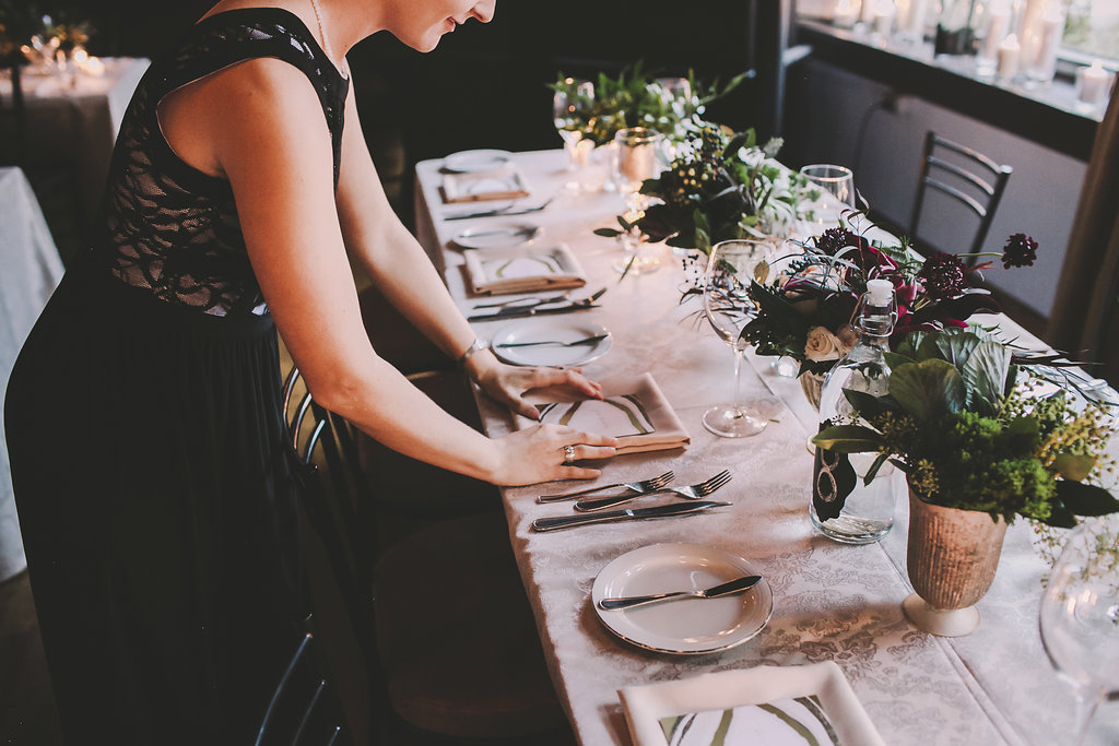 a picture of a woman setting up the table