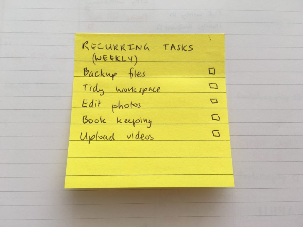 a list of weekly recurring tasks written on a yellow paper