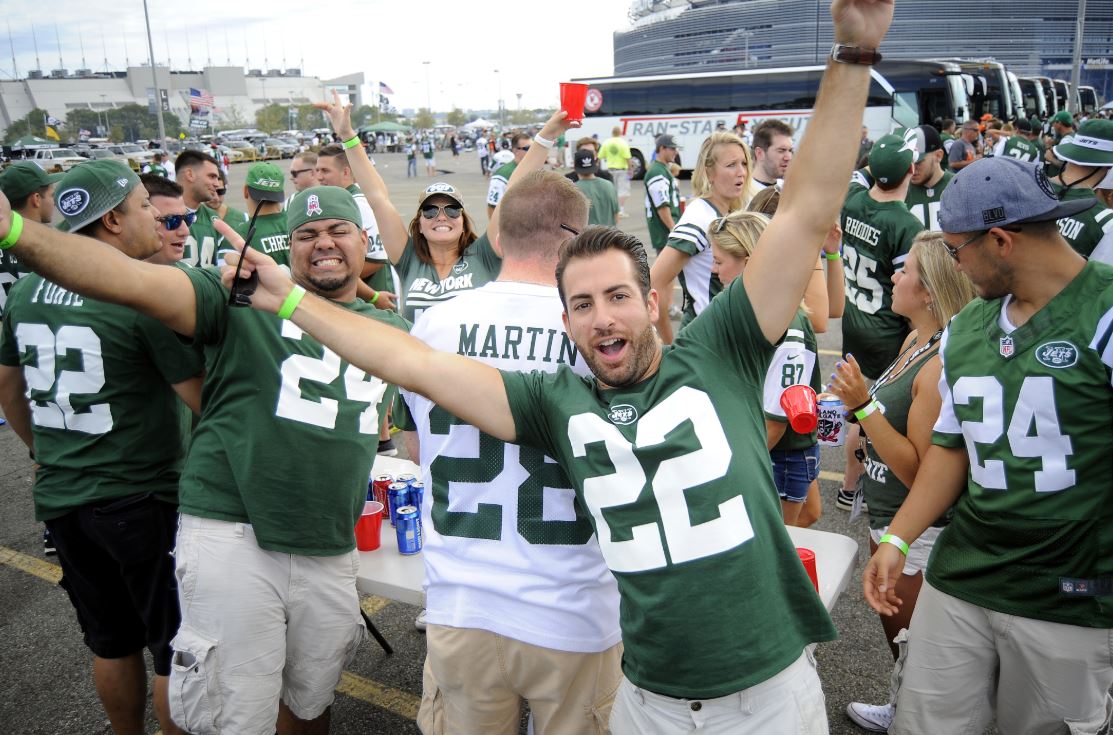 people raised their hands in green uniforms to the tailgating team