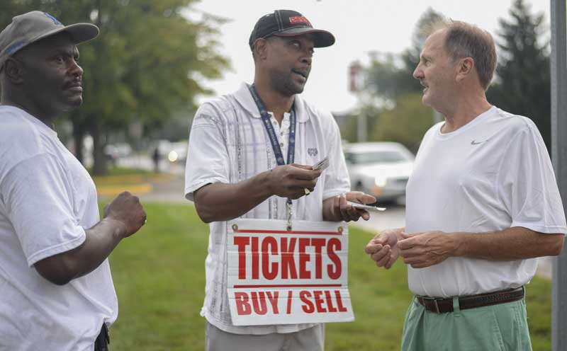 man wearing cap who resale tickets for events outside the venue