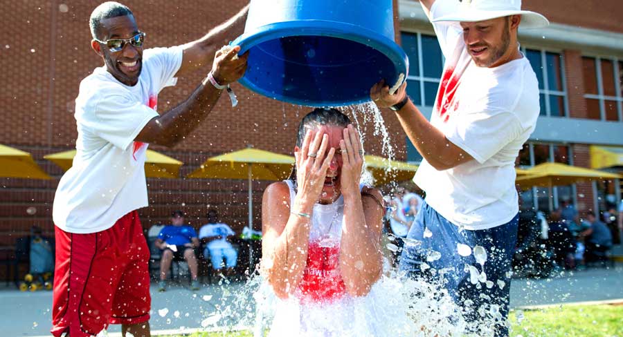 two men poured the woman an ice bucket