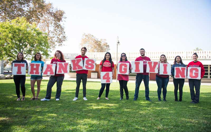 group of youth holding "thanks 4 giving" banner with red letters