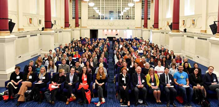 a seated crowd of people in a conference