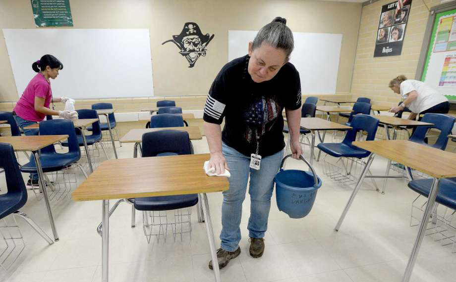 volunteers wiping down classroom desks