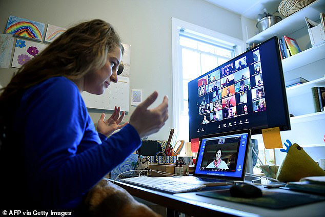 student e-learning and looking at screen with her professor and other students