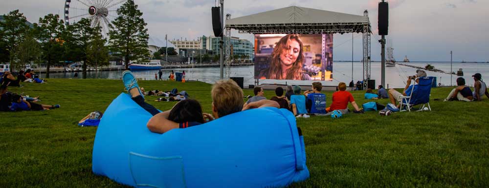 a-man-sitting-outside-watching-a-movie-at-a-park