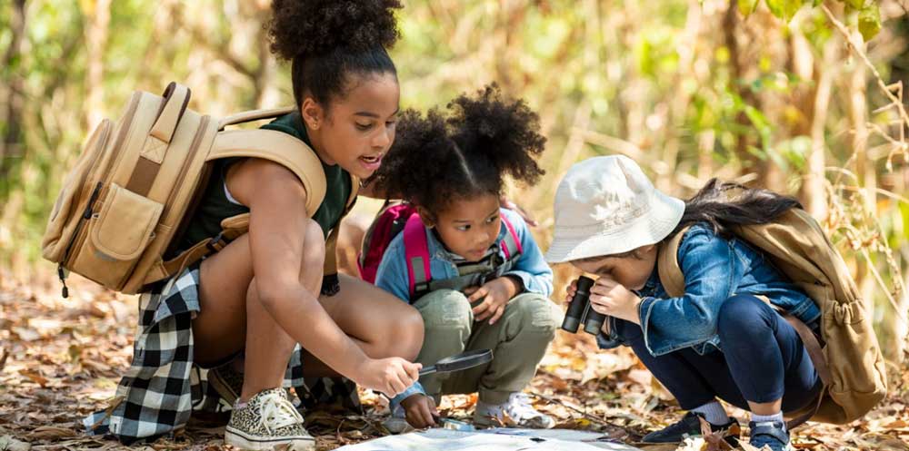kids-outside-reading-a-map-in-nature